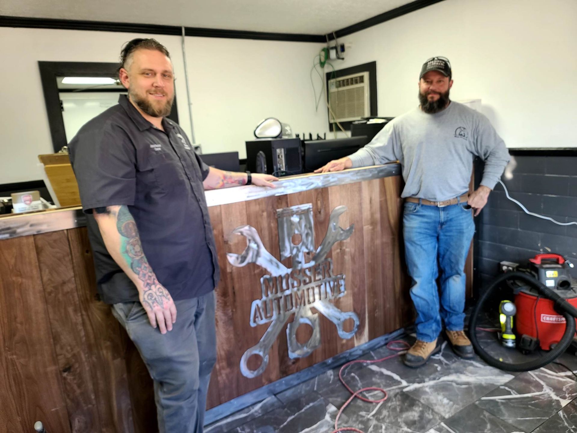 Owner Jason Musser and Daniel Moss in front of the new service writer desk at Musser Automotive.