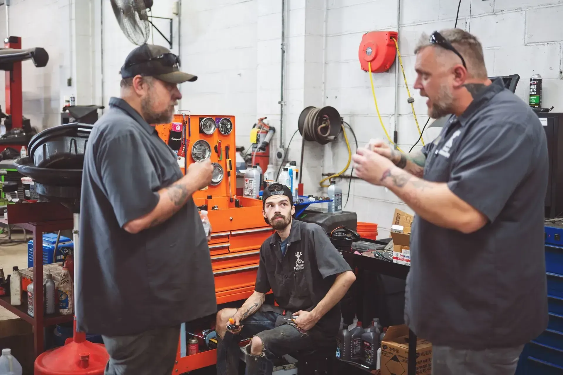 Red vehicle on a lift with tire inflator and tools in the foreground at Musser Automotive.