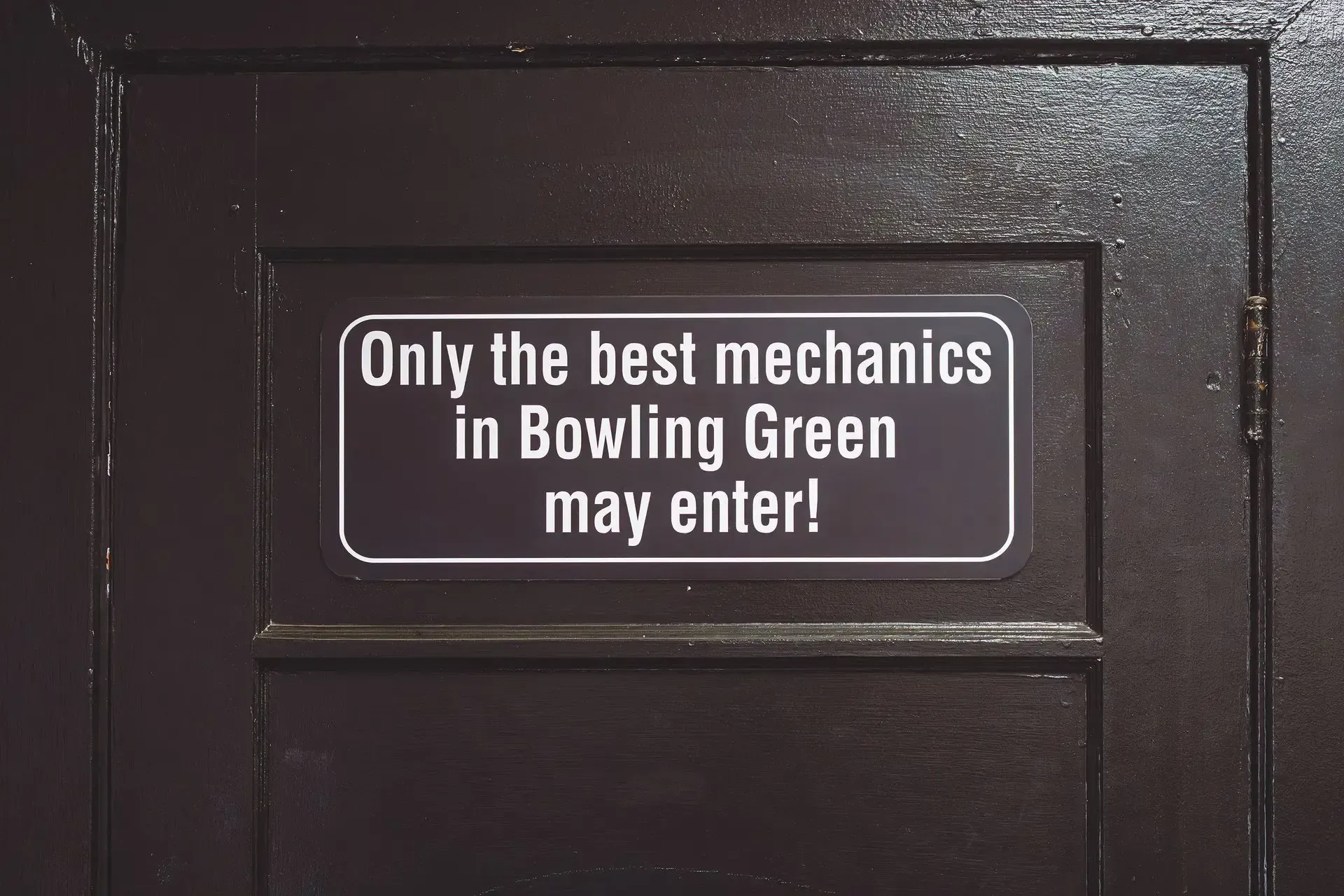 Sign on a dark brown door: