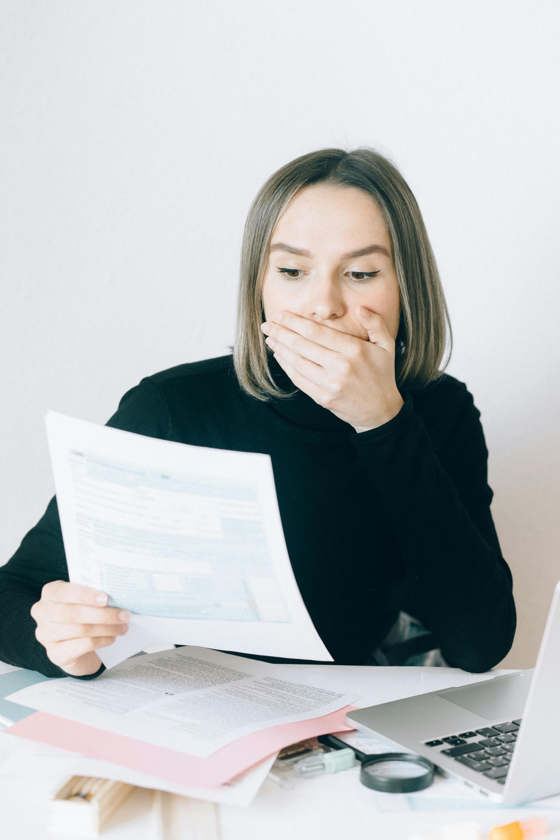 Surprised woman reviewing her estate planning documents, realizing common estate planning myths