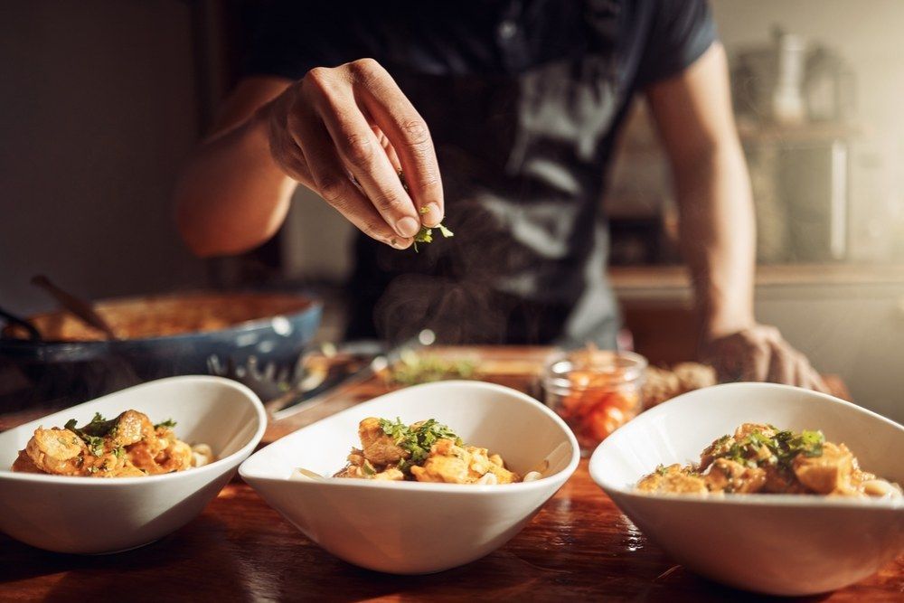 A Man is Preparing Food in Three Bowls on a Wooden Table — Kowin Restaurant in Wingham, NSW
