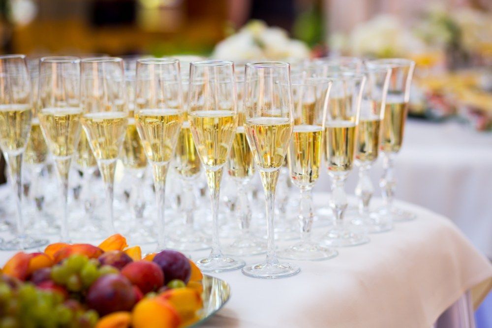 A Table Topped With Glasses of Champagne and a Bowl of Fruit — Kowin Restaurant in Forster, NSW