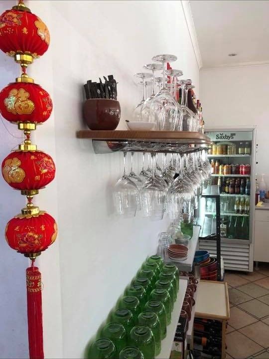 A Shelf With Wine Glasses Hanging on It in a Restaurant — Kowin Restaurant in Old Bar, NSW