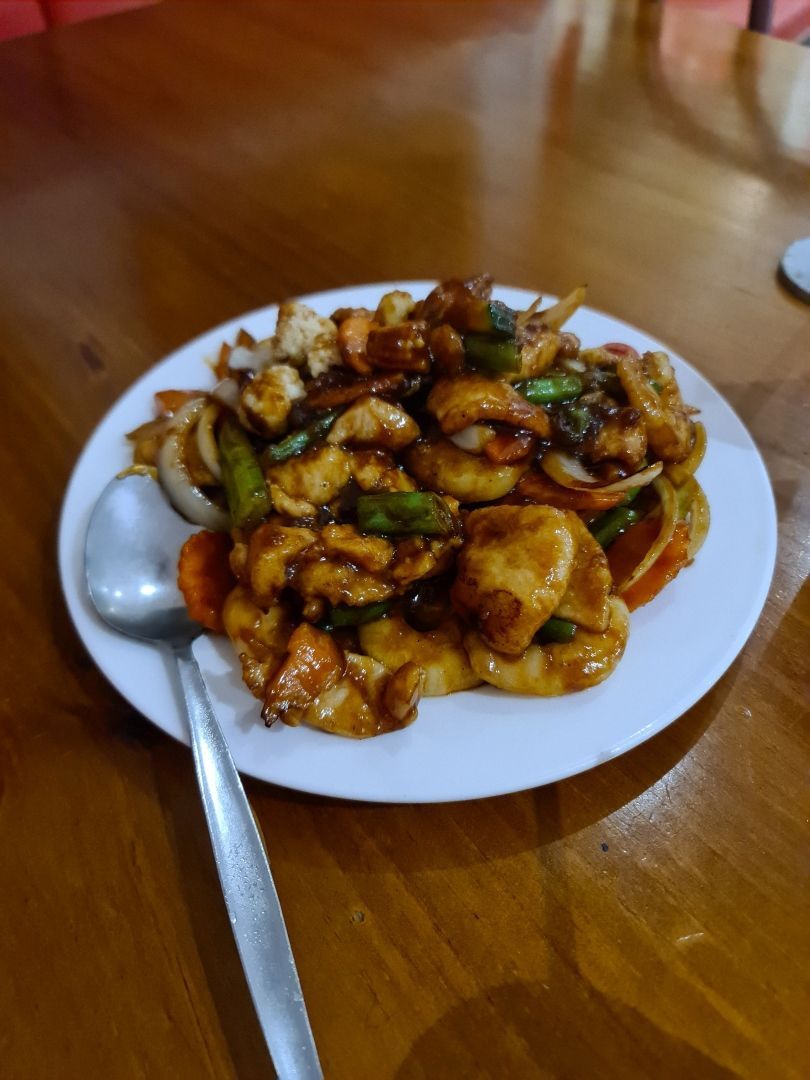 A Plate of Food With a Spoon on a Wooden Table — Kowin Restaurant in Harrington, NSW