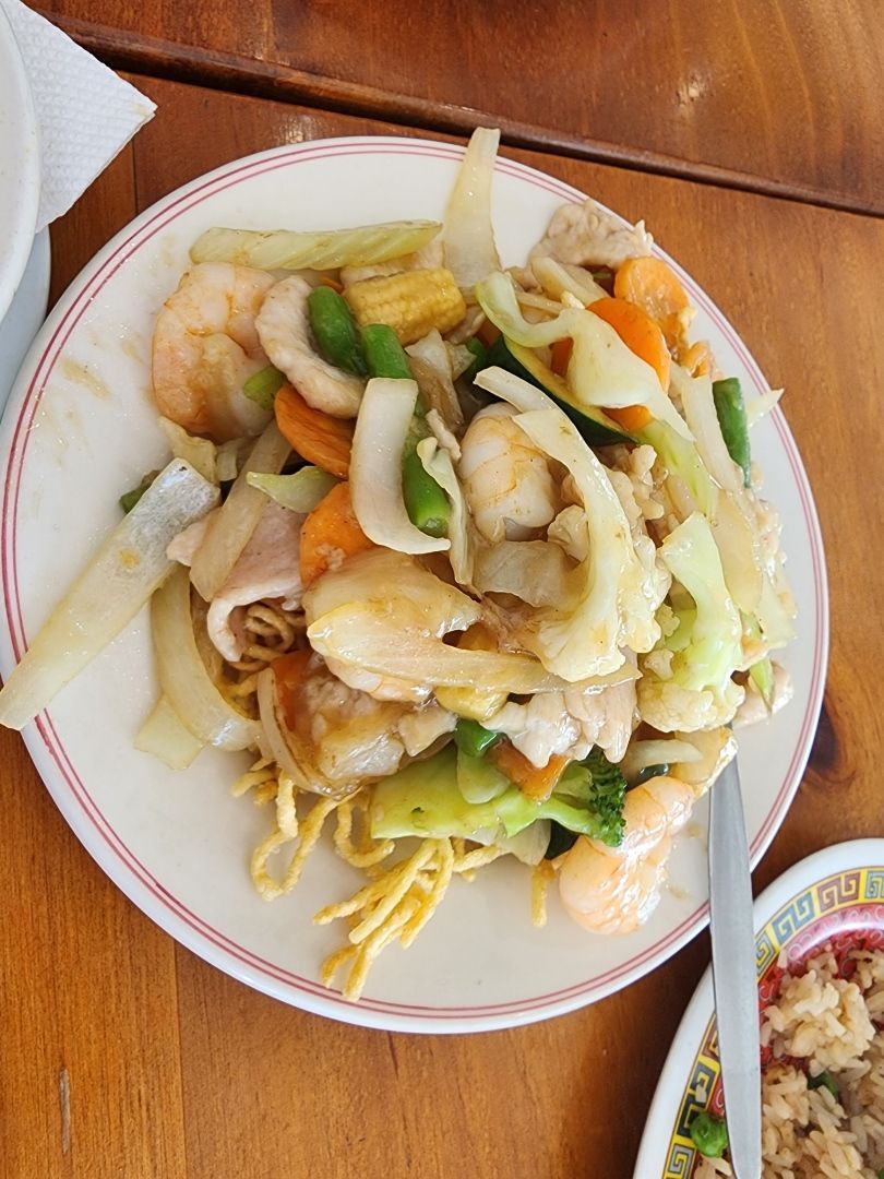 A White Plate Topped With Noodles and Vegetables on a Wooden Table — Kowin Restaurant in Wingham, NSW