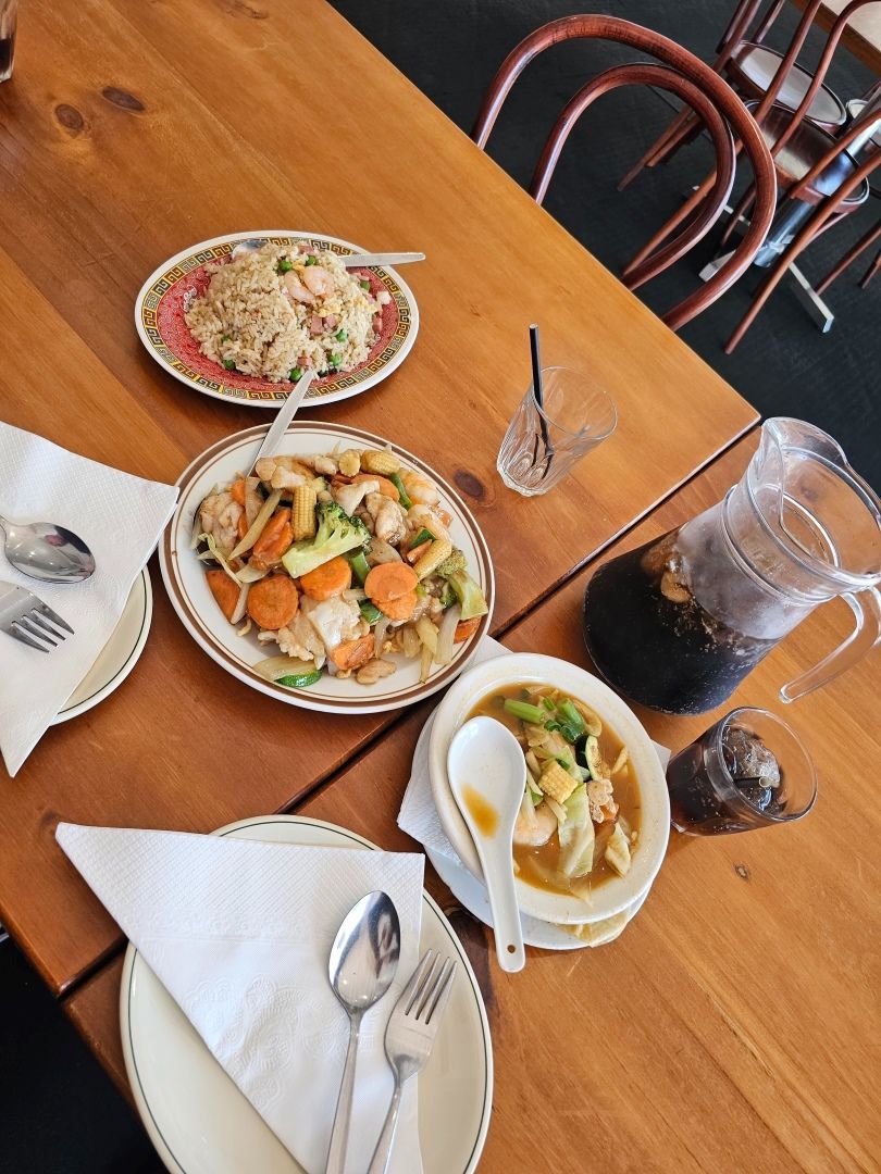 A Wooden Table Topped With Plates of Food and Utensils — Kowin Restaurant in Wingham, NSW