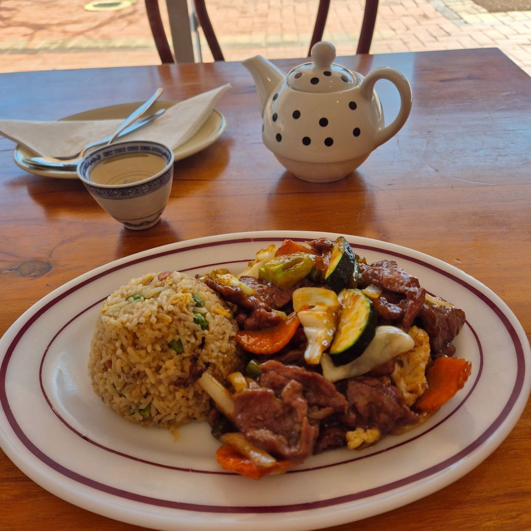 A Plate of Food on a Table Next to a Teapot — Kowin Restaurant in Taree, NSW