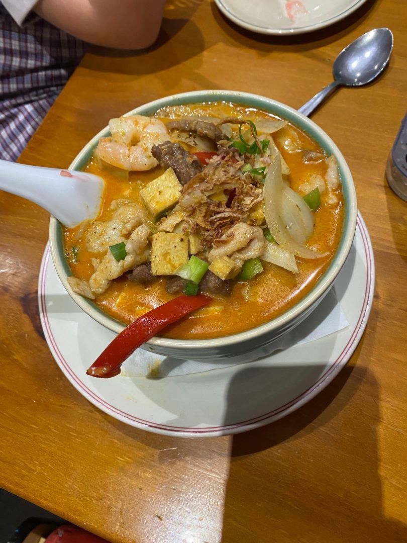 A Bowl of Soup With a Spoon in It on a Wooden Table — Kowin Restaurant in Taree, NSW