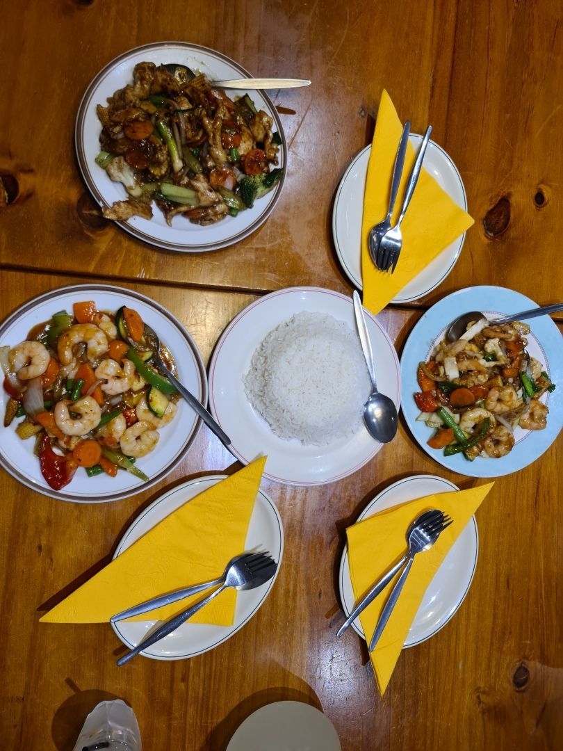 A Wooden Table Topped With Plates of Food and Utensils — Kowin Restaurant in Harrington, NSW