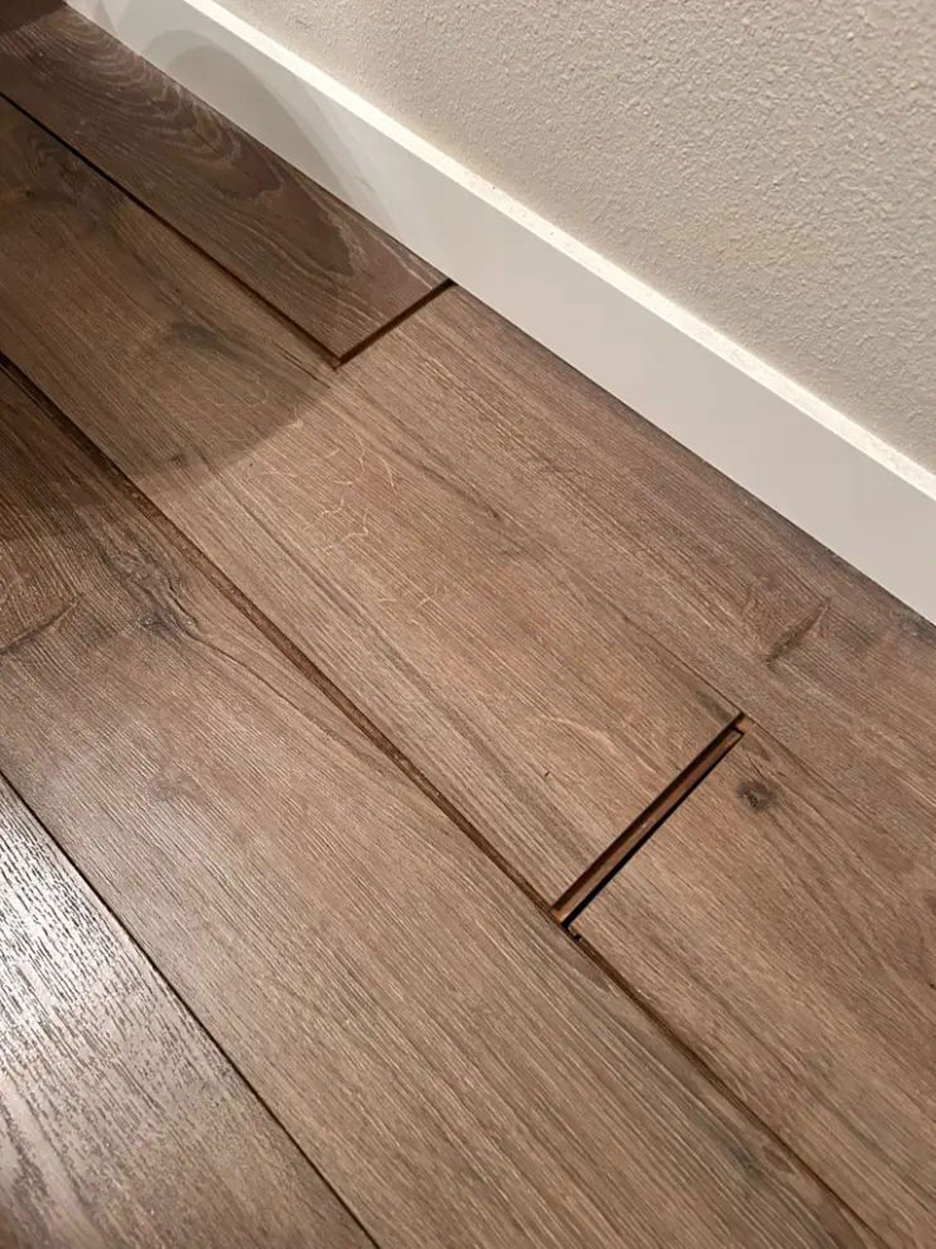 A close up of a wooden floor with a hole in it