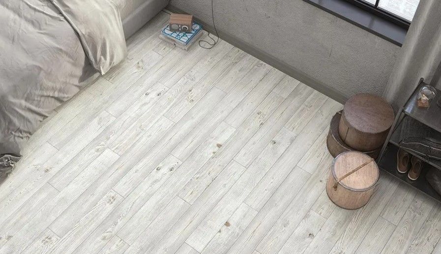 A bedroom with a white wooden floor and a bed.