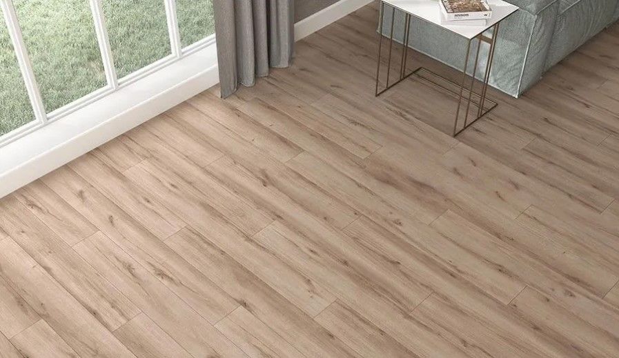 A living room with a wooden floor and a table in front of a window.