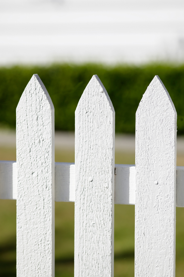 Close-up photo of a white picket fence.