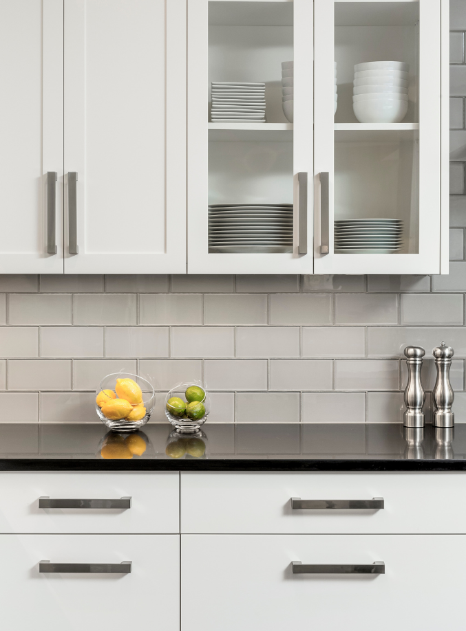 Detail of white kitchen cabinets with black countertop.
