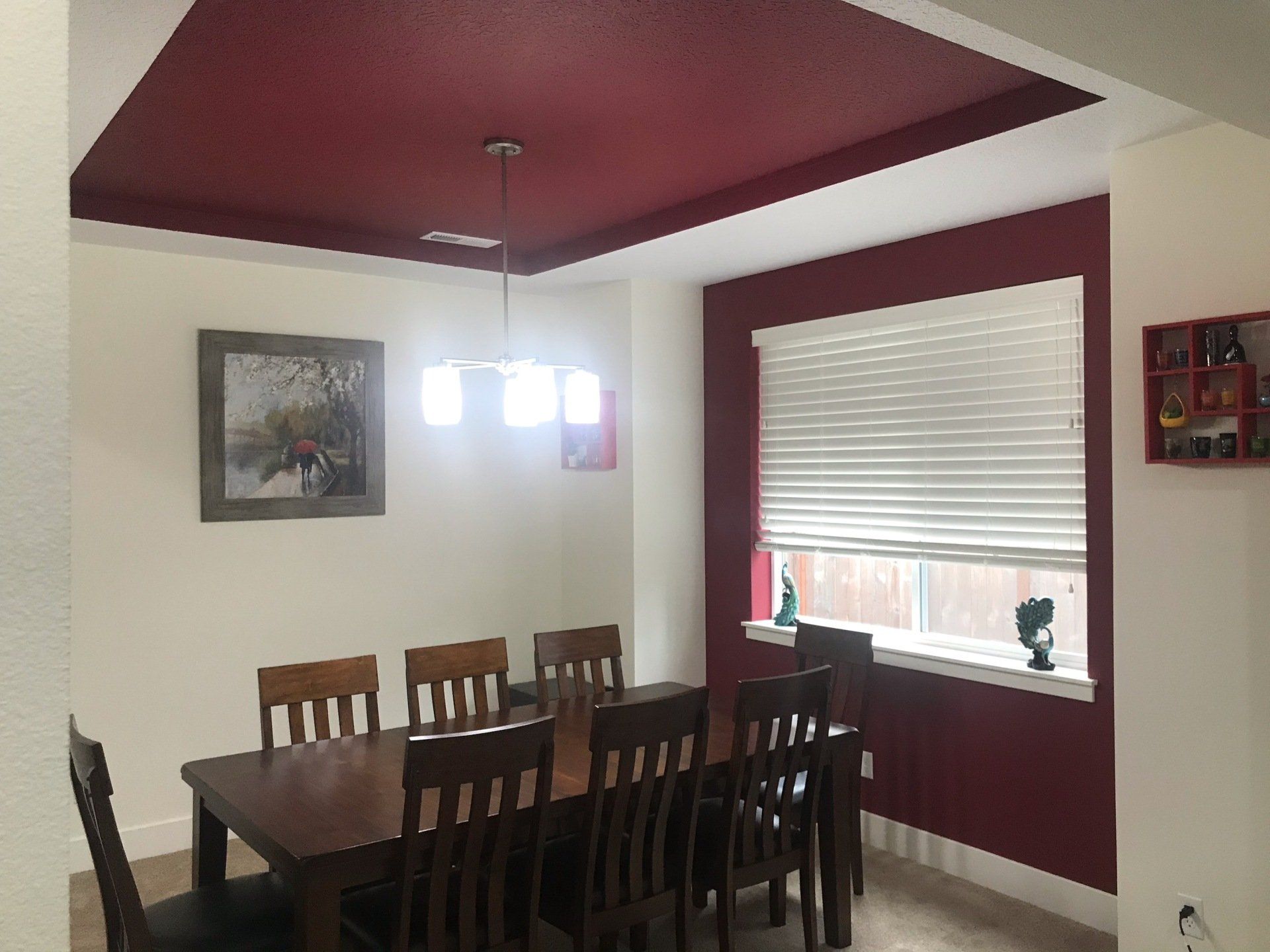 Picture of a dining room with a red ceiling and accent wall.