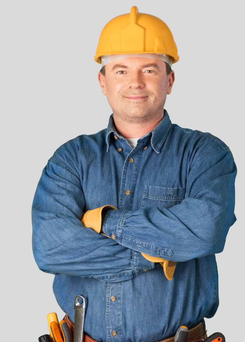 Un homme portant un casque de chantier est debout, les bras croisés