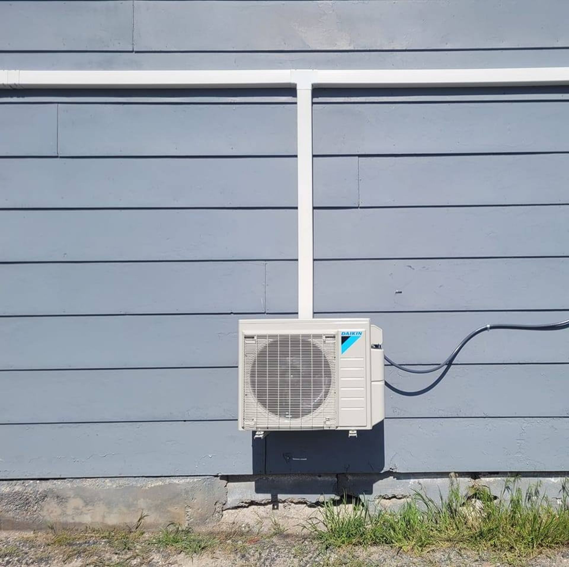 A daikin air conditioner is attached to the side of a building