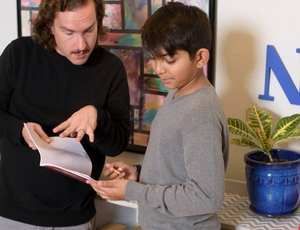 Montessori guide and child reflect together during a one-on-one conference
