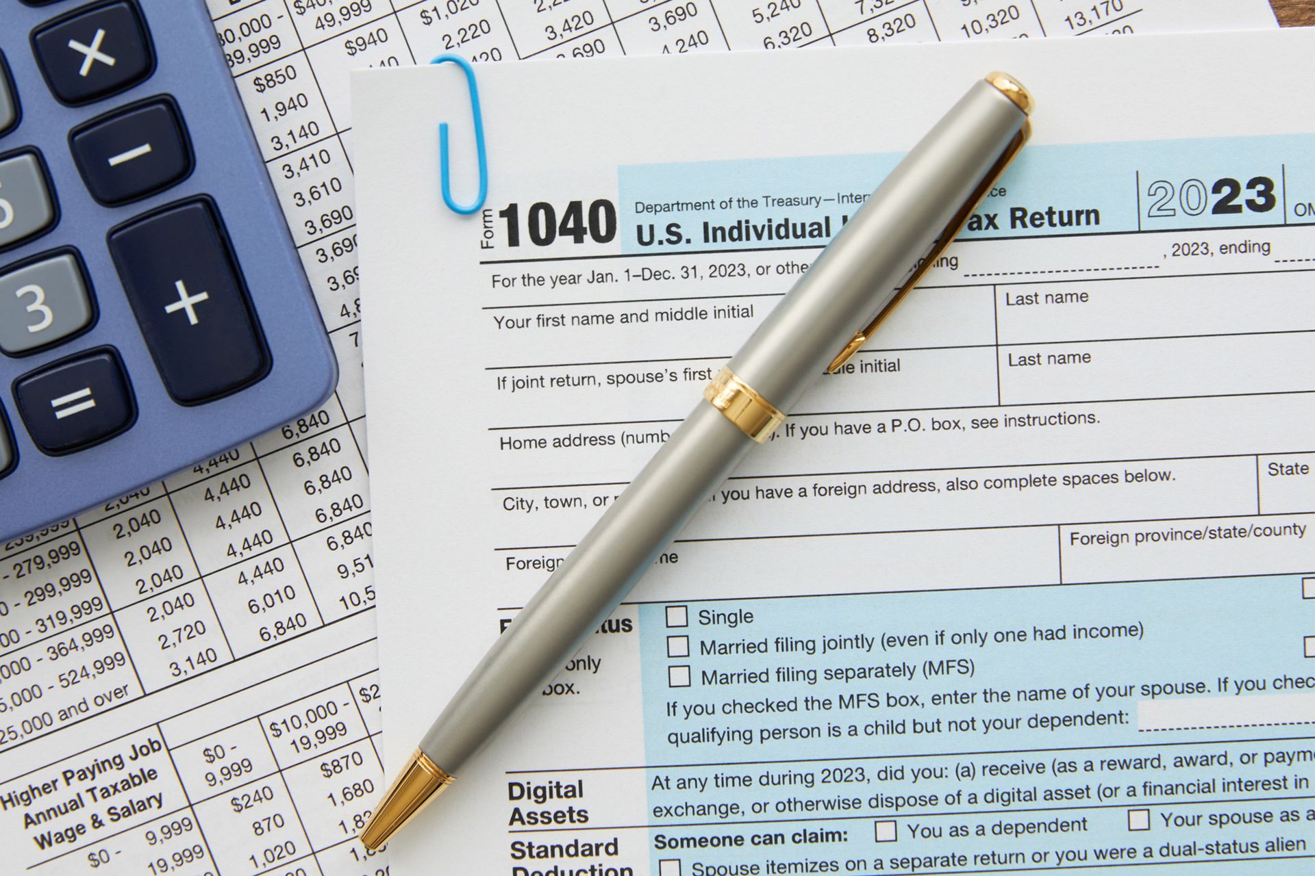 1040 tax form with a pen and calculator on top.