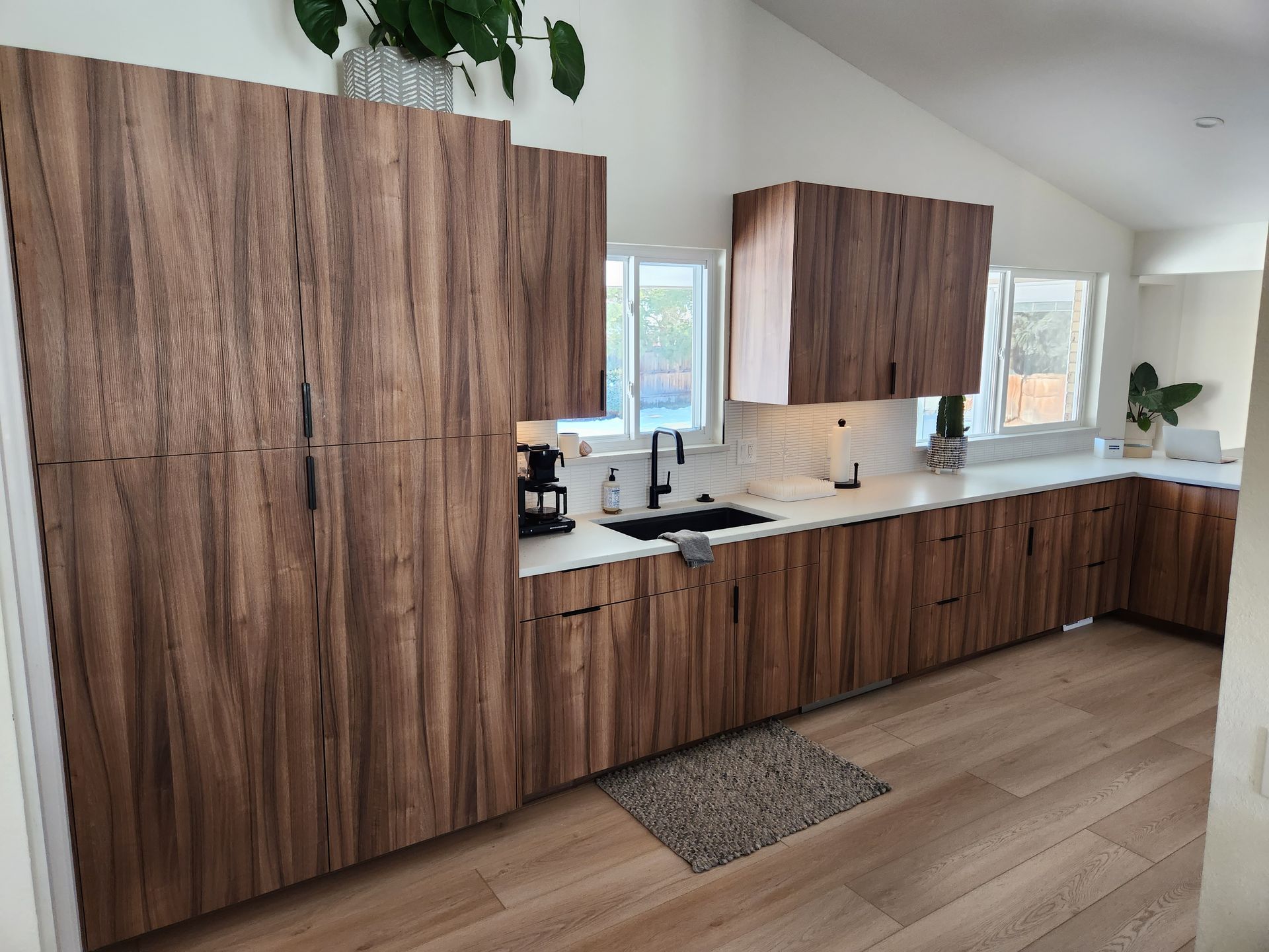 A woman and a child are loading dishes into a dishwasher in a kitchen.