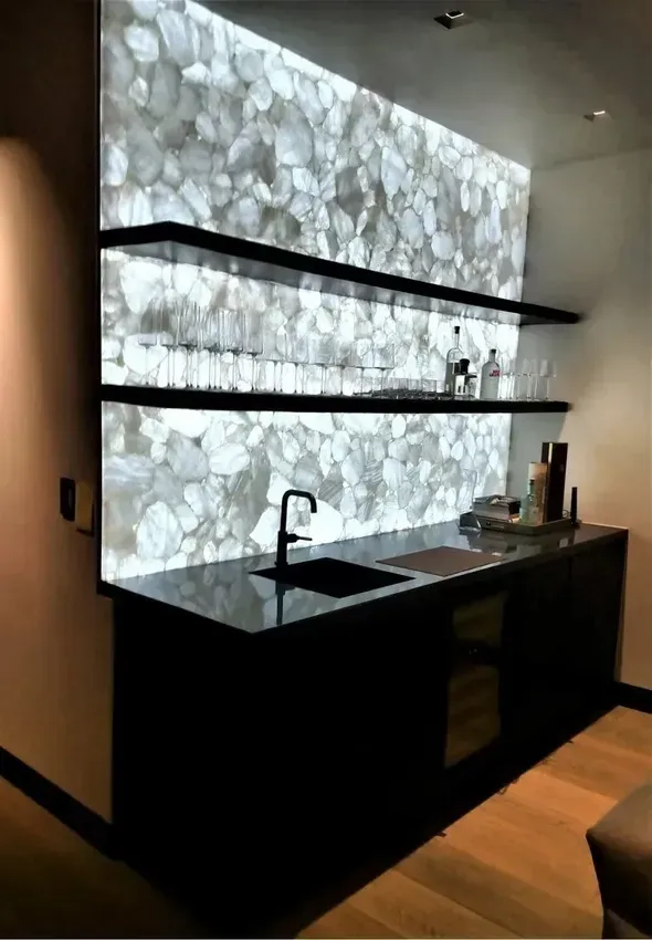 A kitchen with a stove top oven , a window , and pendant lights hanging from the ceiling.