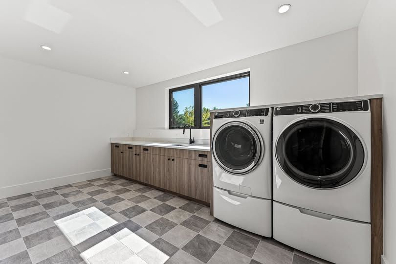 A laundry room with a washer and dryer and a checkered floor.