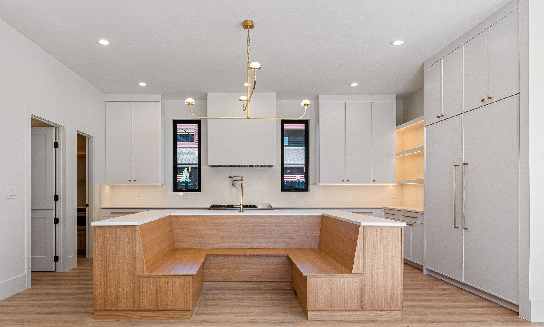 A kitchen with white cabinets and a wooden bench in the middle.
