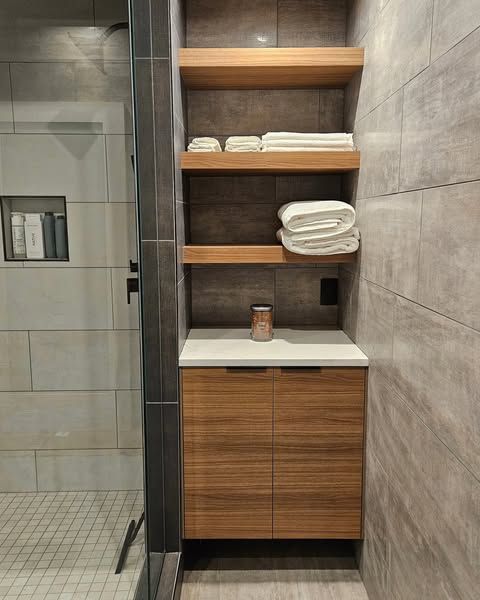 A bathroom with a sink and shelves filled with towels.