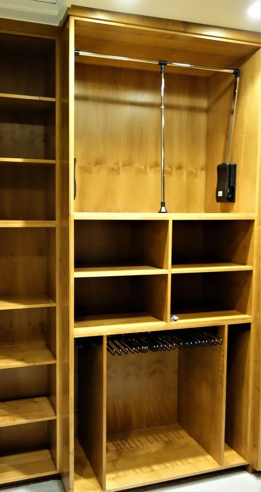 A wooden closet with lots of shelves and hangers
