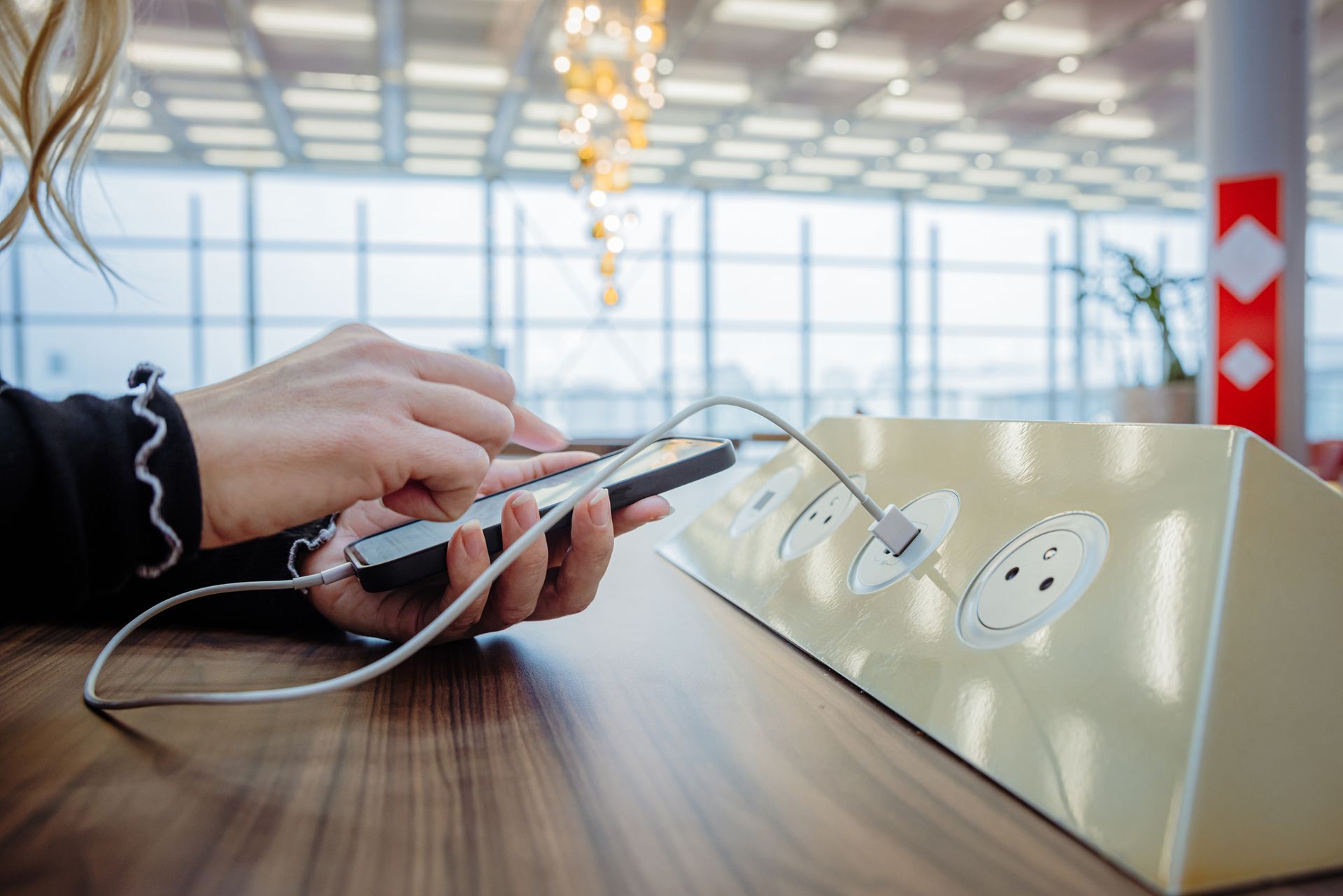 A person is charging a cell phone on a table.