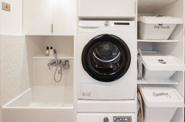 A laundry room with a washer and dryer and white cabinets.