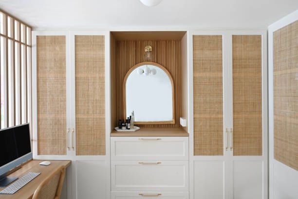 A room with wicker cabinets and a desk with a computer on it.