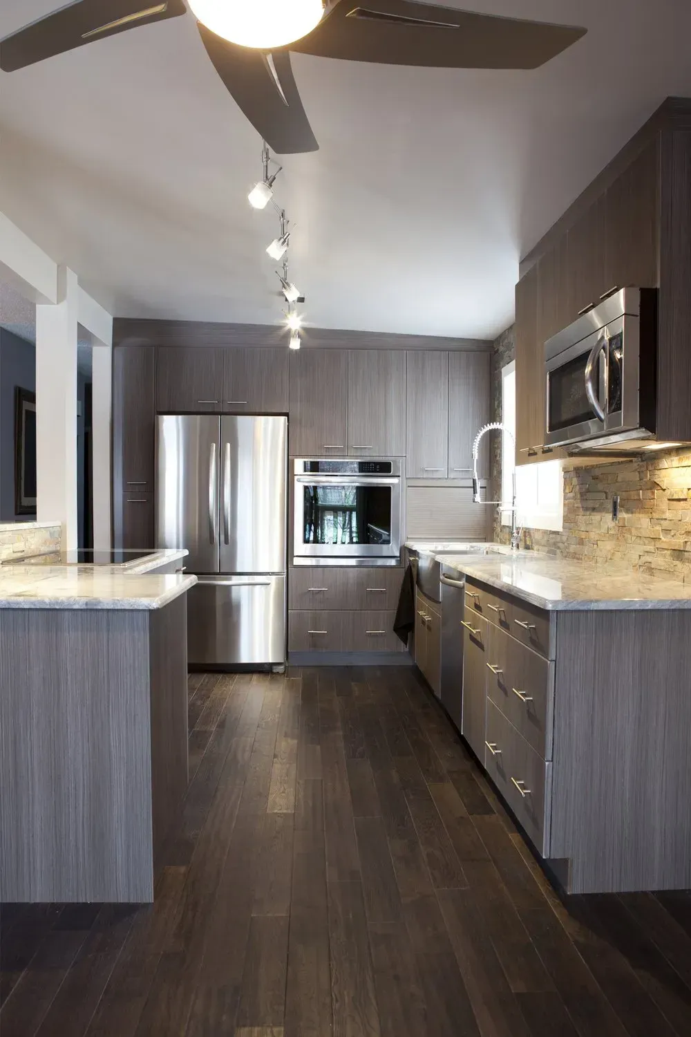 A kitchen with stainless steel appliances and a ceiling fan.