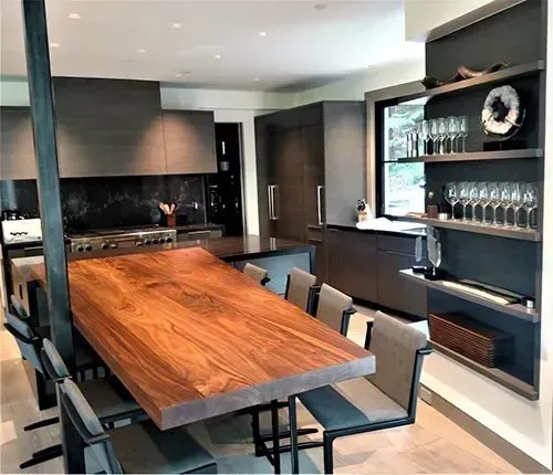 A kitchen with white cabinets and a wooden bench in the middle.
