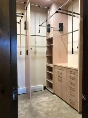 A walk in closet with lots of shelves and drawers.