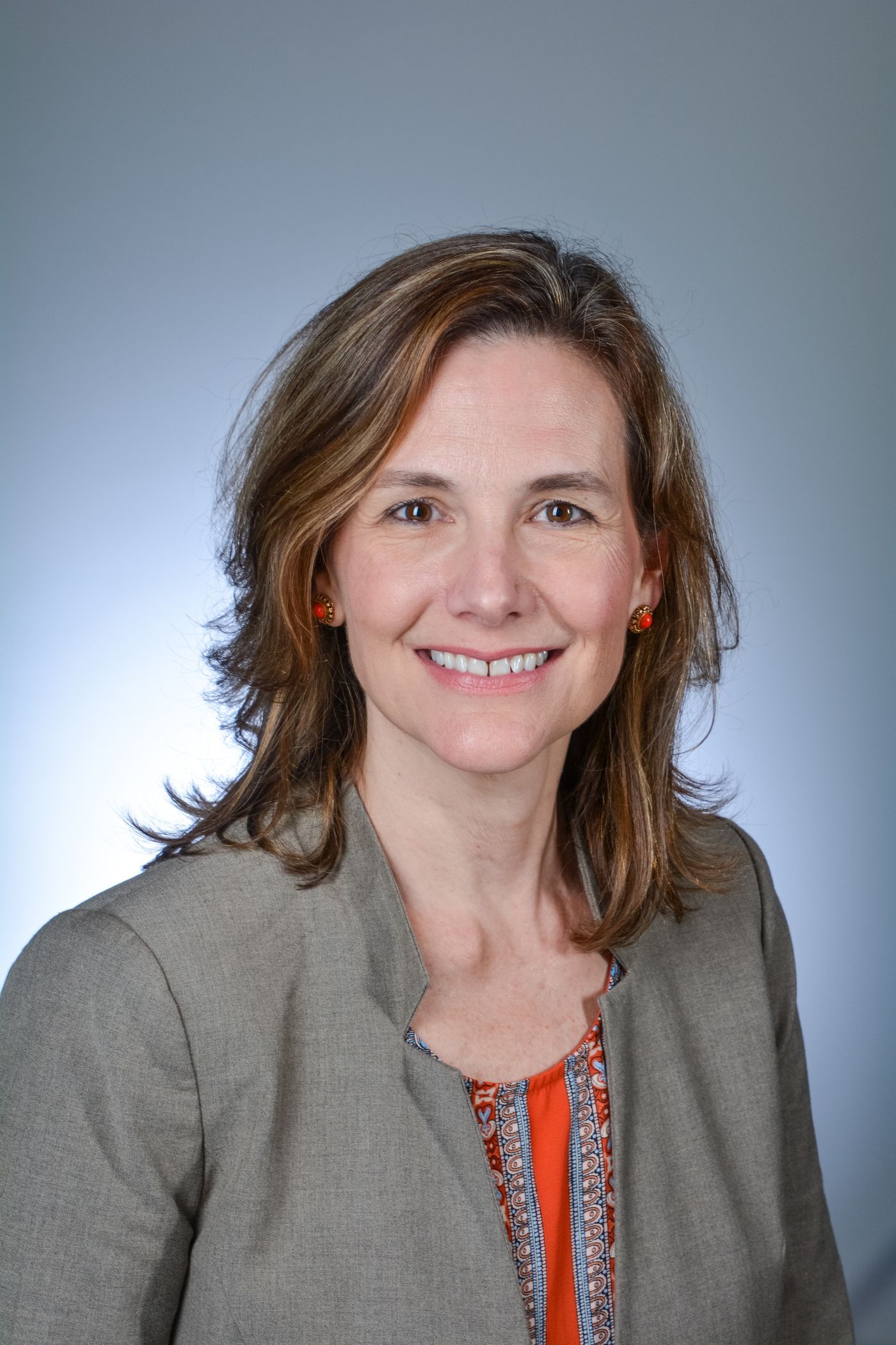 Woman with shoulder-length brown hair smiles at the camera. 