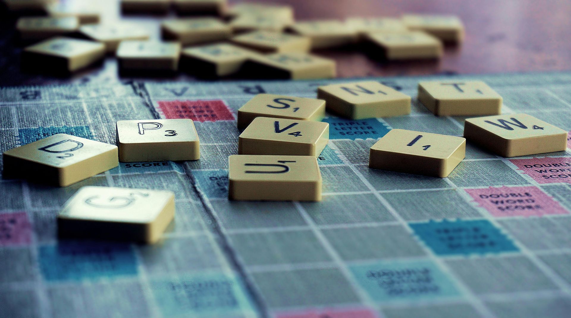 Scrabble game board with beige letter tiles, some spelling