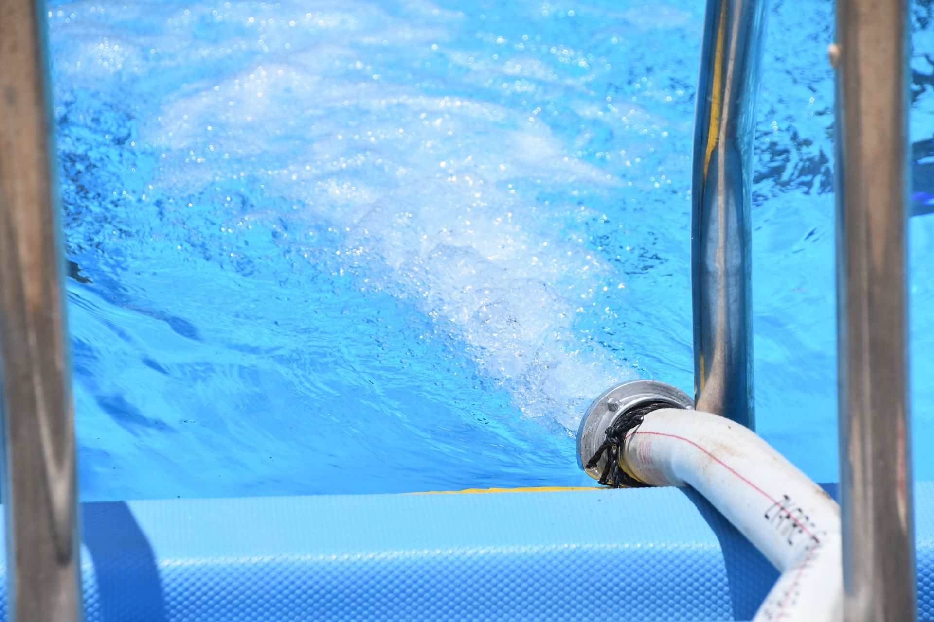 A hose is being used to pump water into a swimming pool.