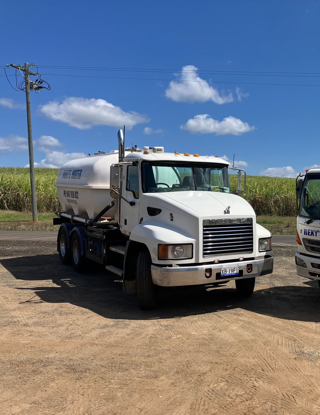 A water truck is spraying water on the road