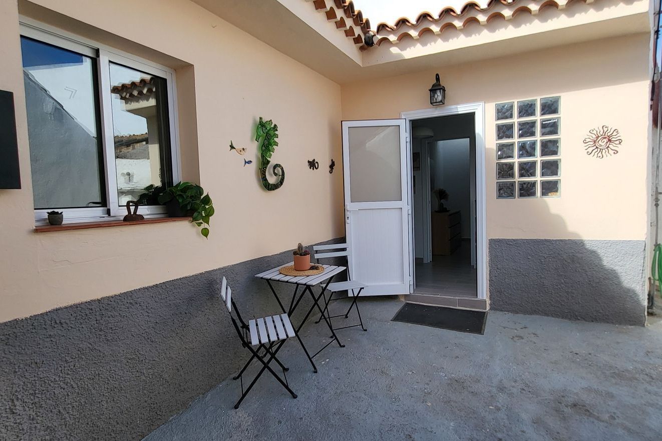 Innenhof mit Tisch und Stühlen in der Nachmittagssonne