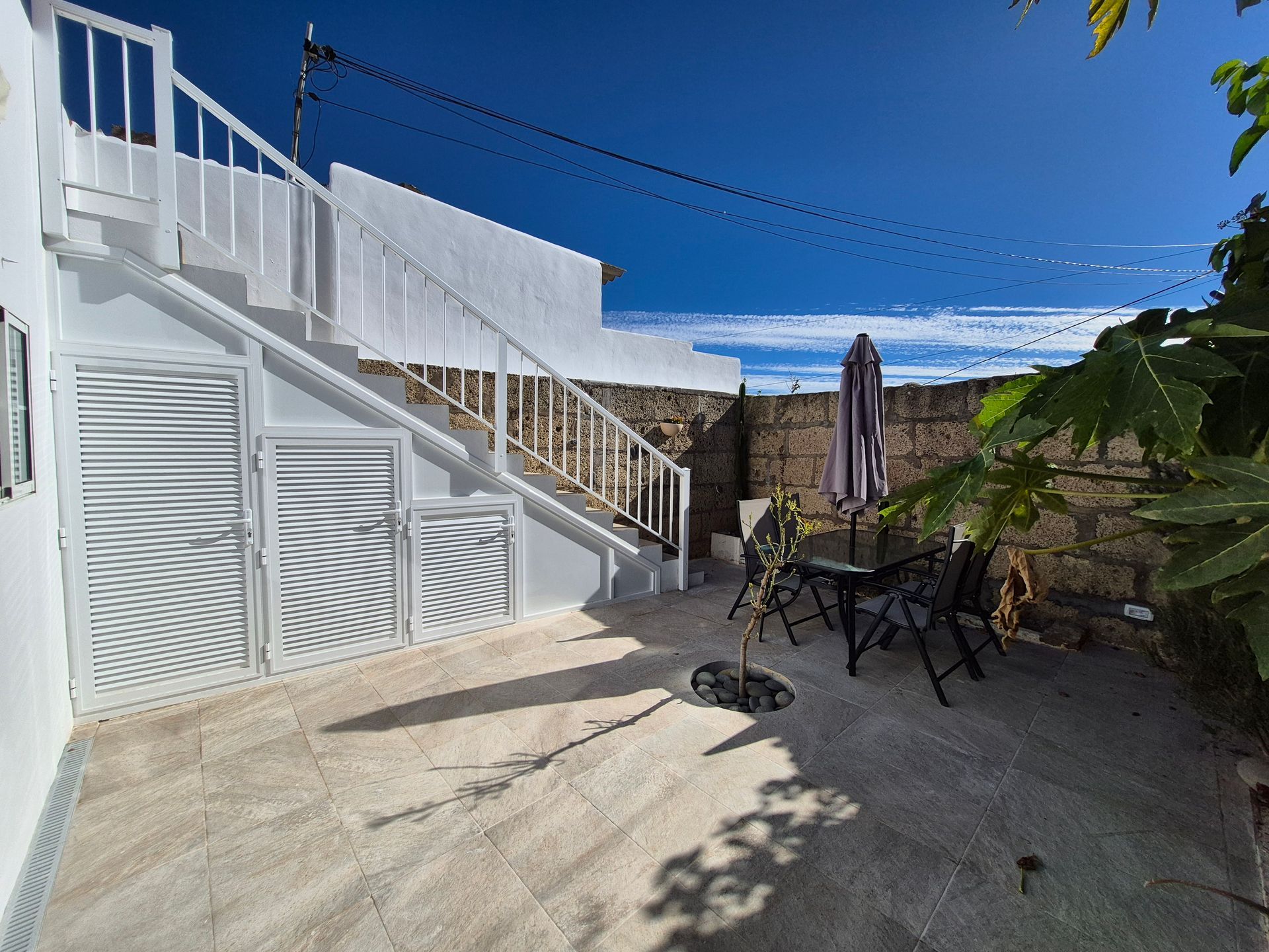 Terrasse mit Tisch und Stühlen.