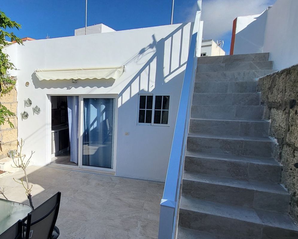 Terrasse und der Eingang zum Haus sowie eine Treppe auf das Dach