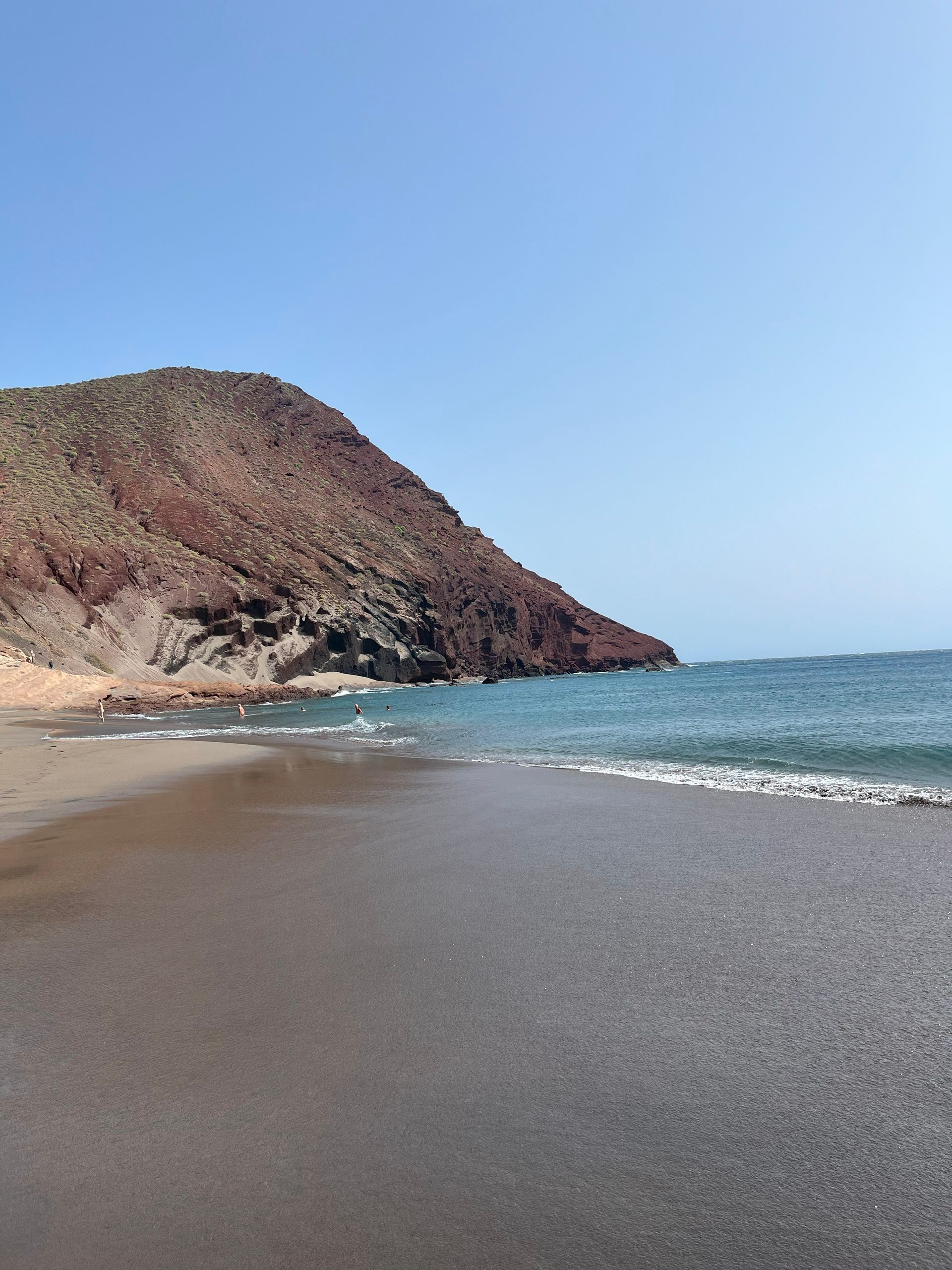Ein Strand mit einem Berg im Hintergrund