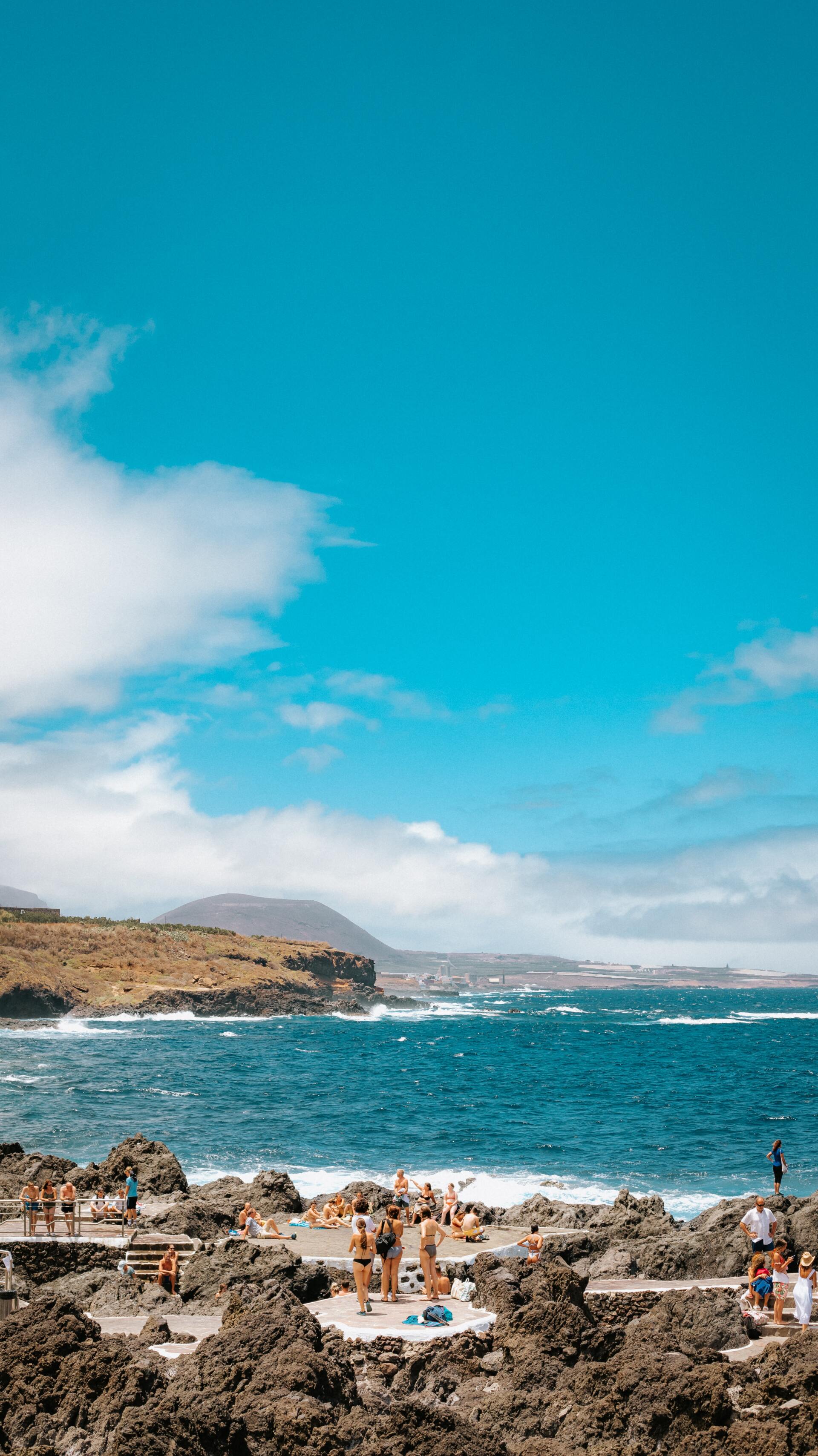 Eine Gruppe von Menschen steht an einem felsigen Strand in der Nähe des Ozeans.