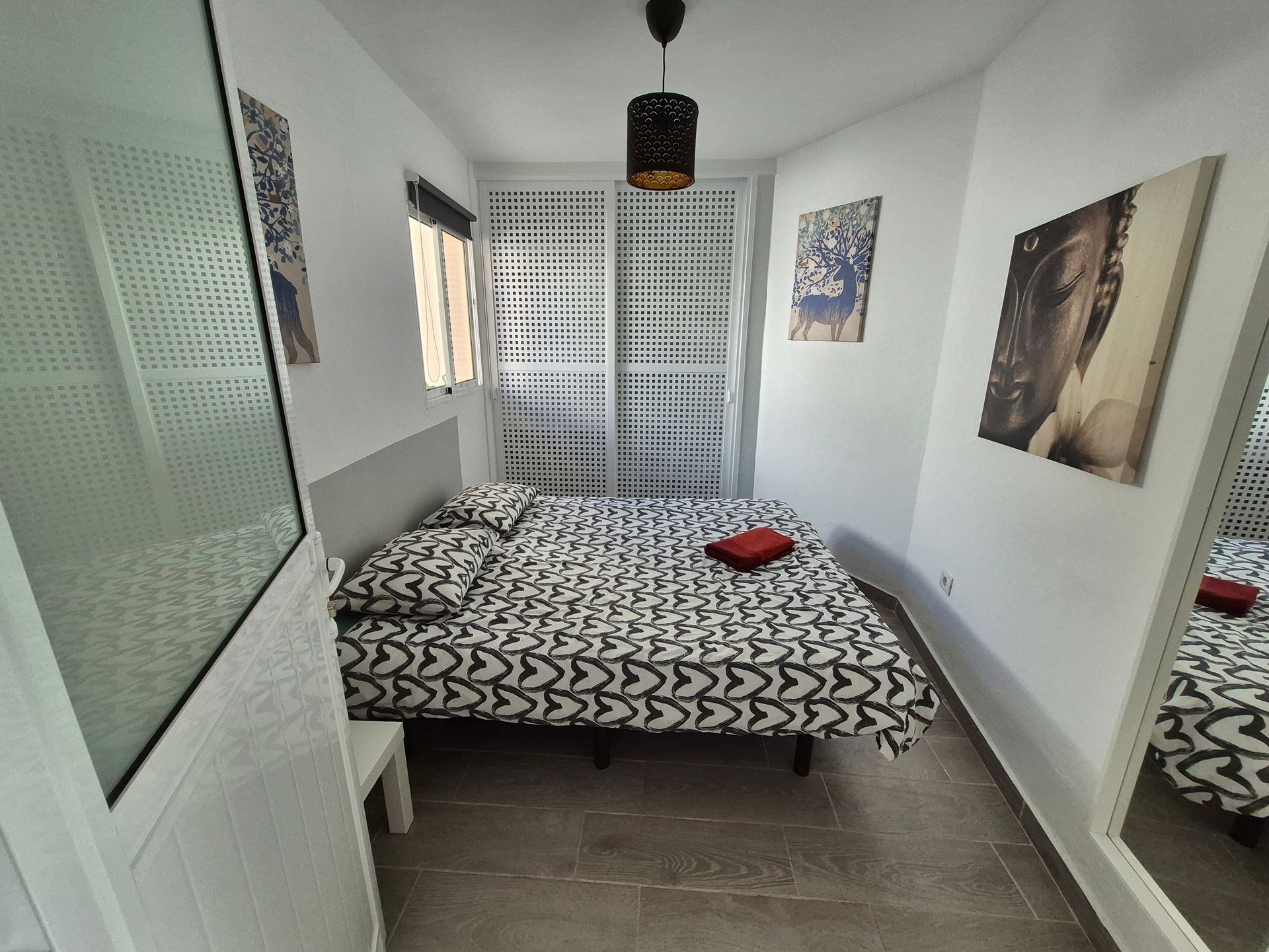 Das zweite Schlafzimmer mit einem Bett und einem Spiegel