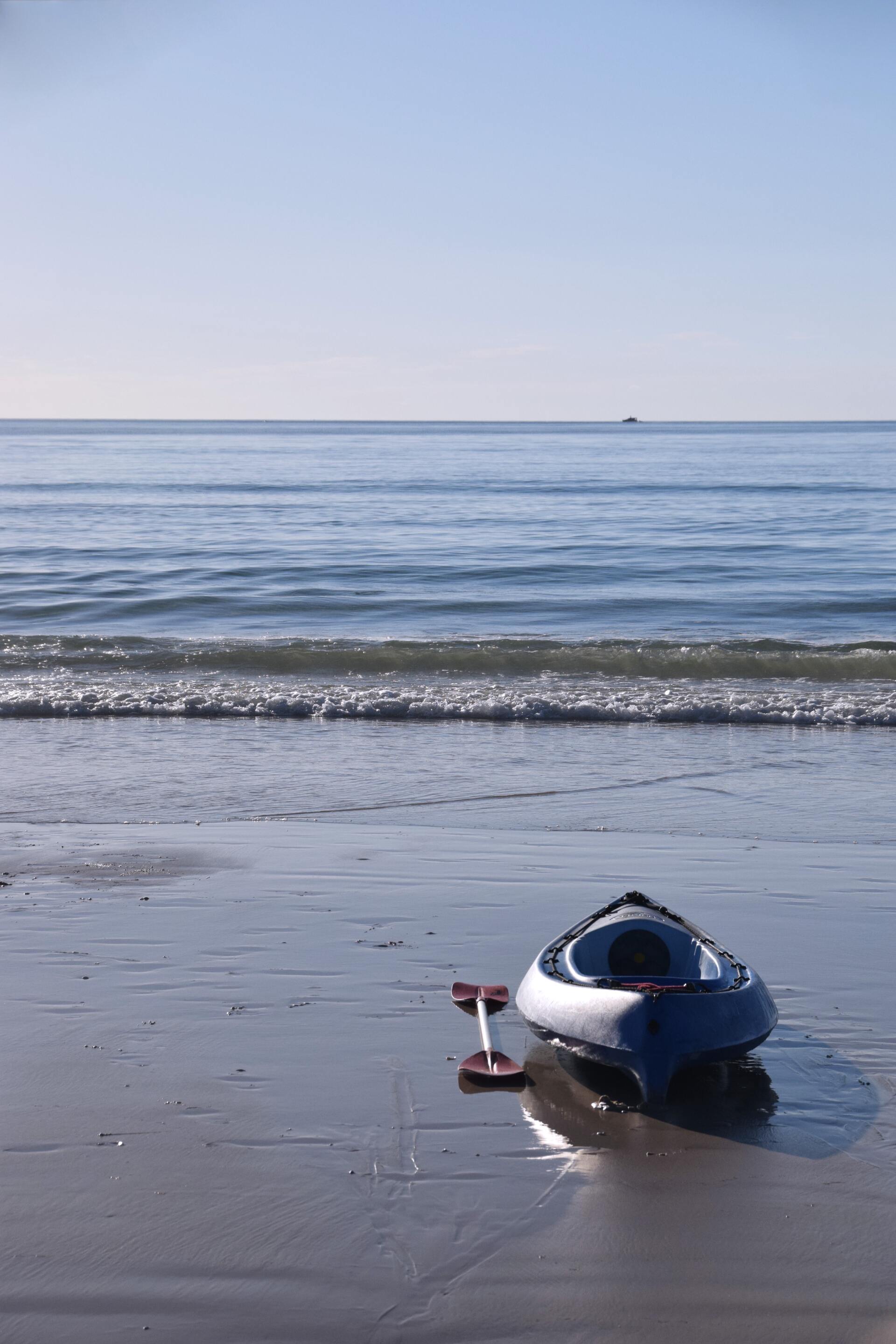 Ein Kajak liegt am Strand in der Nähe des Ozeans