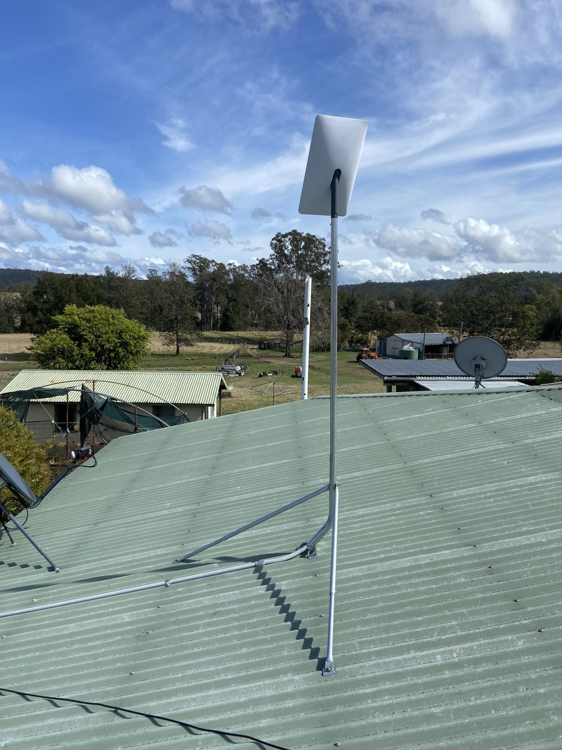 A satellite dish is sitting on top of a green roof.