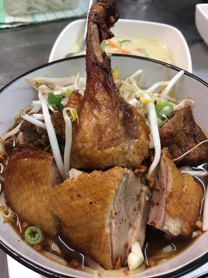 A close up of a bowl of food with meat and vegetables on a table.