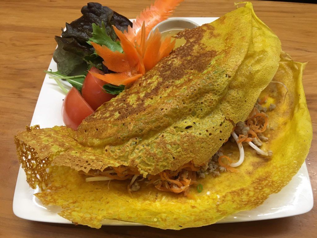 A close up of a plate of food with vegetables on a table.