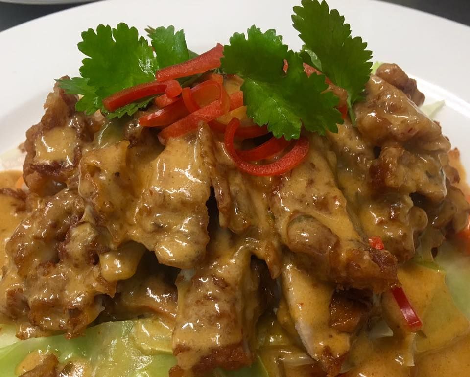 A close up of a plate of food with sauce and vegetables